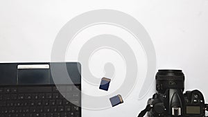 Photographer`s workplace on a white background. Modern laptop, digital camera, memory card. Top view. Copy space. Equipment for