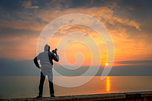 Photographer in seaside with beautiful sunrise background. Khobar Corniche -Saudi Arabia