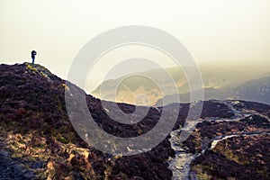 Photographer silhouette on a scottish mountain in a cloudy day