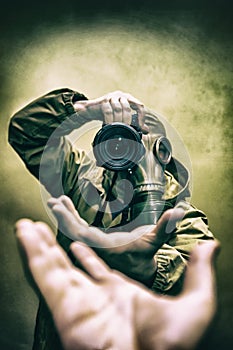 Photographer stalker, military correspondent with a camera in military uniform in a protective gas mask closeup