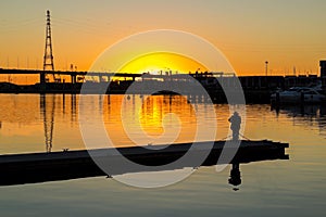 A photographer stands on a pier to take photos