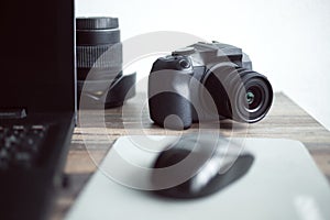 Photographer or stock photography concept, digital black camera near laptop on desk workstation