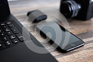 Photographer or stock photography concept, digital black camera near laptop and phone on desk workstation