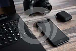 Photographer or stock photography concept, digital black camera near laptop and phone on desk workstation
