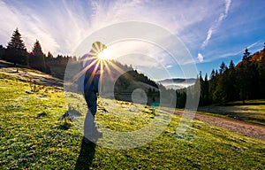 Photographer in sunburst shooting foggy landscape