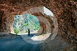 Photographer takes picture in tunel to Piva river pass.