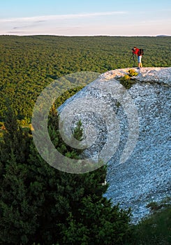 The photographer takes pictures of the scenery on the rock