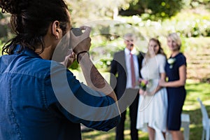 Photographer taking photo of bride and her parents