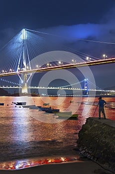 Photographer taking photo of Ting Kau Bridge and Tsing Ma Bridge in Hong Kong at night