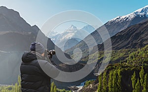 Photographer taking photograph of Hunza valley landscape in Pakistan by dslr camera