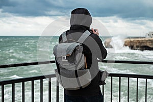 Photographer taking picture of a stormy sea in Polignano a Mare, Italy photo