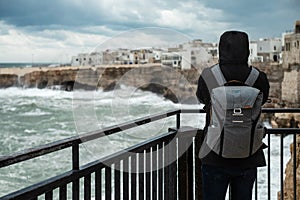 Photographer taking picture of a stormy sea in Polignano a Mare, Italy photo