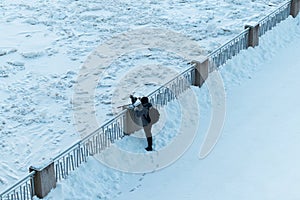 Photographer taking a pictures of a frozen lake from a shore railing after a cold winter night