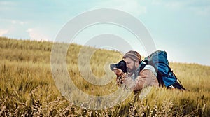 Photographer taking pictures among grass