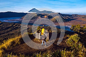 Photographer on the top of mountain to take a sunrise photo by drone for Bromo vocano