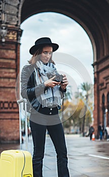 Photographer tourist look retro photo camera. Girl in hat travels in Triumphal arch Barcelona. Holiday concept in europe city