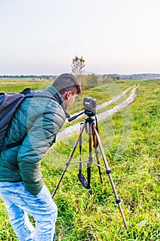 Photographer traveler adjusts the camera lifestyle professional activity hiker