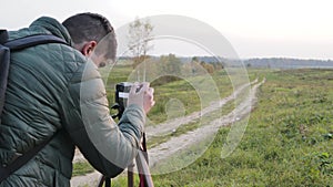 Photographer traveler adjusts the camera lifestyle professional activity hiker