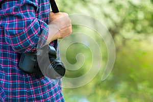 Photographer or traveler concept. Photographer holding digital camera in his hands with copy space photo