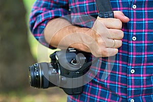 Photographer or traveler concept. Photographer holding digital camera in his hands photo