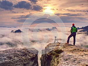 Photographer traveler thinking close to tripod with camera