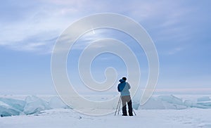 Photographer using camera tripod taking landscape photography in bad weather with overcast sky in the morning