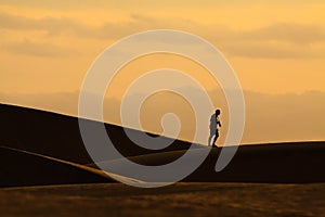 Photographer walking on sand dunes in Maspalomas