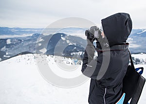 Photographer in the winter, on top of the mountain