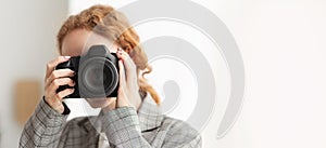 Photographer. Woman covering face with professional camera