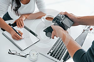 Photographer at work. Two young female freelancers indoors in the office at daytime