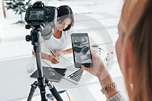 Photographer at work. Two young female freelancers indoors in the office at daytime