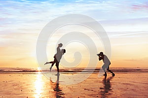 Photographer working with couple on the beach, professional wedding photography