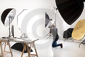 Photographer working in modern lighting studio with many kinds