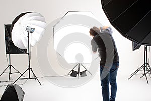 Photographer working in modern lighting studio with many kinds