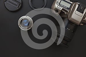 Photographer workplace with dslr camera system and lens on dark black table background. Hobby travel photography concept. Flat lay