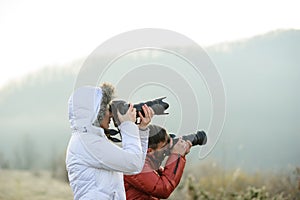 photographers with cameras outdoor making landscape pictures