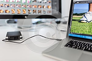 Photographers computer with photo edit apps/programs running photo