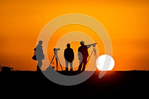 Photographers silhouetted against the setting sun photo