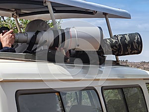 Photographers with telephoto lenses taking pictures on a game drive in Samburu National Park, Kenya