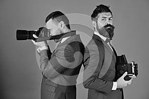 Photographers working. Men with beards hold photo cameras on blue background