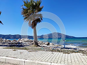Photographic shot of the Adriatic-Ionian sea facing a pyramidal mountain against the sky