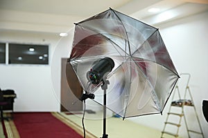 Photographic studio strobe lighting and reflective umbrella . Photo studio Silver Photo Studio Reflective Umbrella