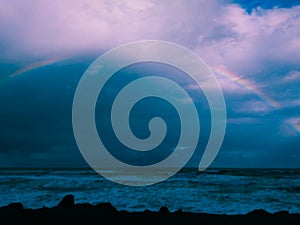 photographing rainy day with rainbow on the beach