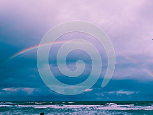 photographing rainy day with rainbow on the beach