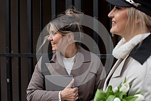 Photography of blond young women smiling having fun during vocations outside In not crowded street
