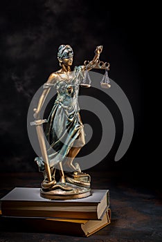 Photography of bronze themis sculpture, femida or justice goddess on dark background