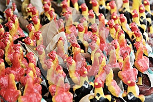 a photography of a bunch of figurines of chickens on a table, confectionary figurines of chickens are displayed on a table