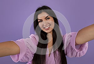 Photography concept. Portrait of positive armenian woman taking selfie picture, making front selfportrait