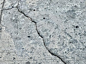 a photography of a crack in the concrete of a sidewalk, nail holes in the concrete of a sidewalk