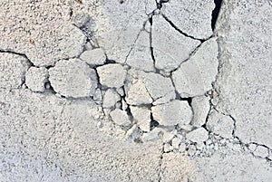 a photography of a crack in the concrete wall with a small piece of rock, stone wall with cracks and cracks in it